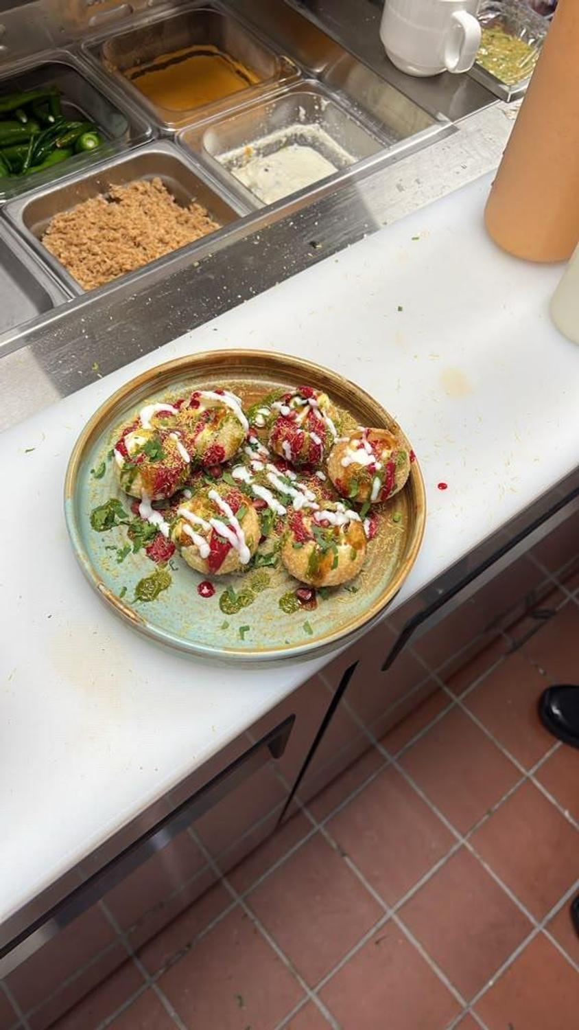 Dahi puri topped with yogurt, sev and pomegranate